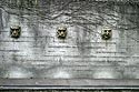 Trois visages de pierre sur mur gris - Baden - © Norbert Pousseur